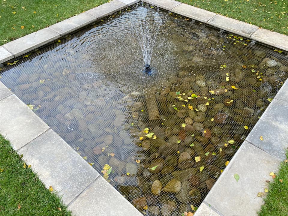The same square pond with clear water after cleaning and a repaired fountain
