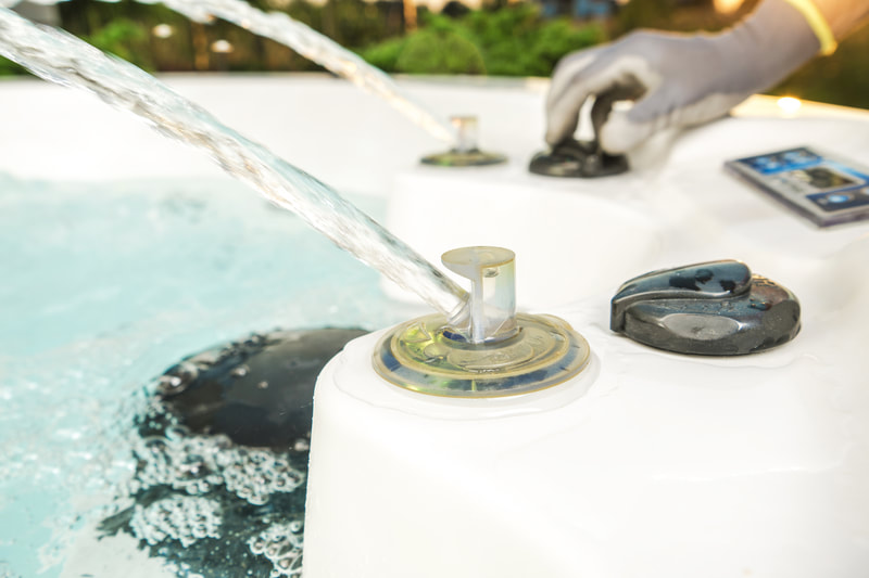 Technician testing hot tub jets while carrying out maintenance